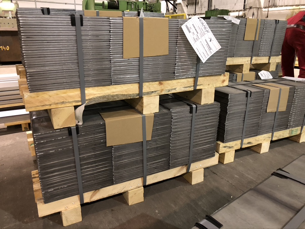 Umreifte Pakete mit Formzuschnitten auf Holzpaletten